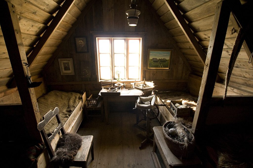 Chambre aménagée sous une toiture en pente avec fenêtre